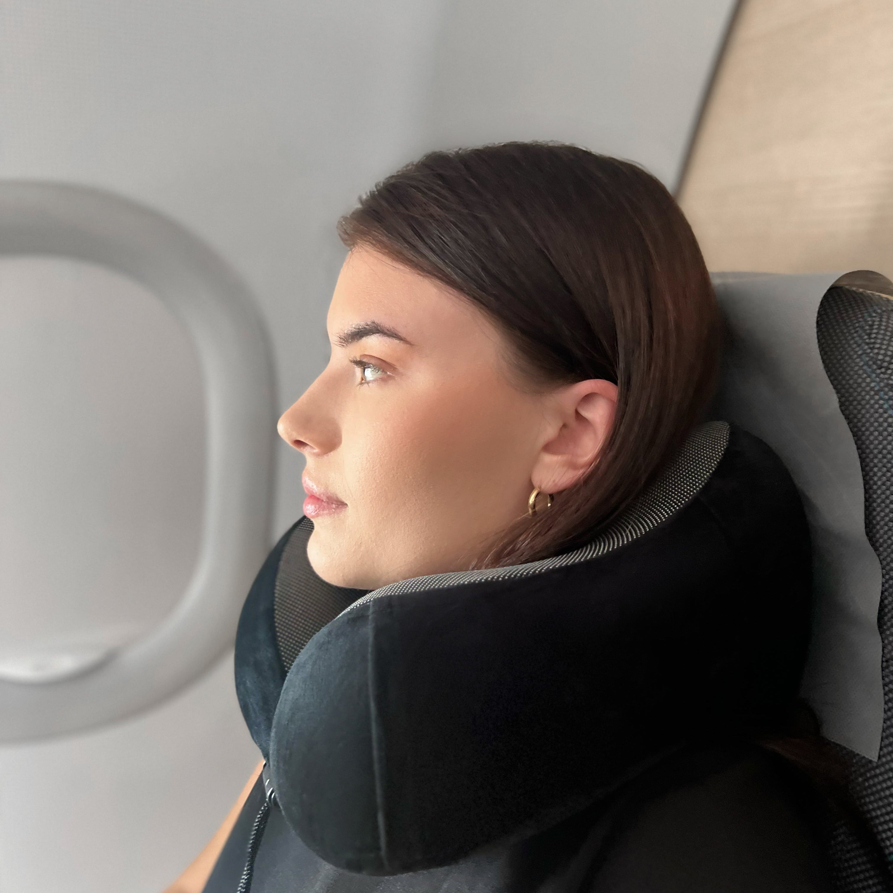 Person som hviler på fly med norzen reisepute for nakkestøtte